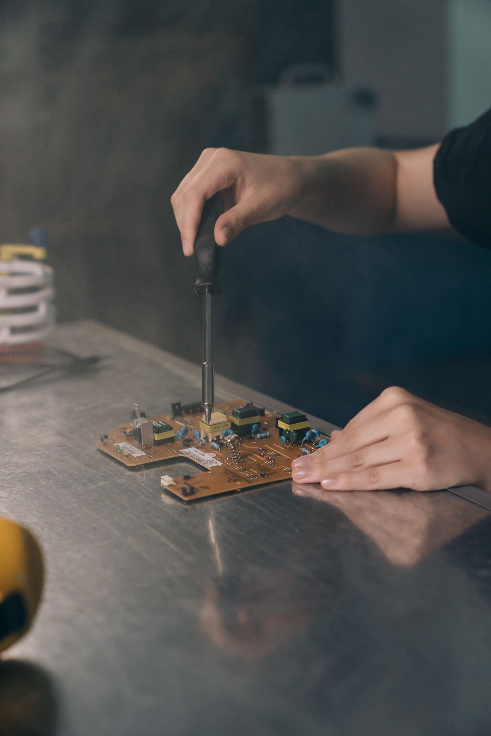 Mains utilisant un tournevis sur un circuit électronique — photo d’illustration